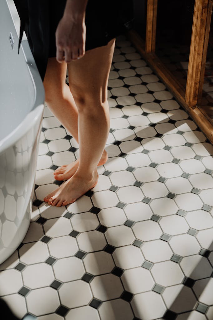 Person Standing on White Ceramic Bathtub